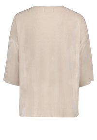 Beżowy, krótkosleeve'owy sweter z luźnym krojem. Posiada teksturowany materiał i szeroki dekolt, kończący się na wysokości talii. Brak widocznych zapięć.