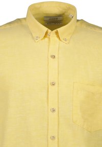 Geel knoopshirt gemaakt van lichte stof. Voorzien van een kraag, een borstzak en parelmoeren knopen. Regular fit ontwerp.