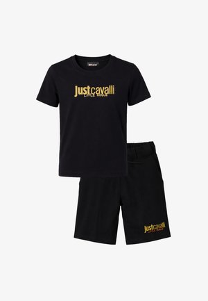 Completo composto da t-shirt nera a maniche corte e pantaloncini, entrambi con il logo testuale dorato "Just Cavalli Little Rogue" sul petto e sulla gamba.
