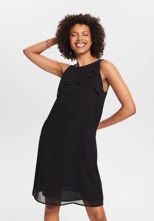 Vestido negro sin mangas en una tela fluida con volantes en capas en el escote; de longitud a la rodilla con un acabado suave.