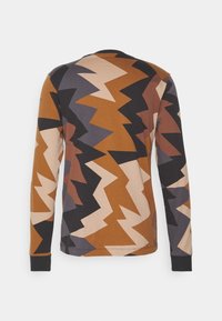 Koszula z długim rękawem z wzorem w błyskawice w odcieniach brązu, beżu i czerni. Wykonana z miękkiego materiału, z okrągłym dekoltem i dopasowanymi mankietami.