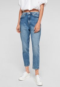 Light blue denim jeans with a straight leg and cropped hem, featuring five pockets, belt loops, and subtle fading. Paired with white sneakers.
