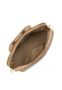 Intérieur d'un sac à main en cuir beige avec une texture lisse, présentant une fermeture éclair et des accents en métal doré. Doublure en tissu doux à l'intérieur.
