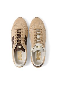 Paire de baskets en daim beige avec des détails perforés, une chaussure avec des rayures marron et l'autre avec des rayures blanches, toutes deux avec des lacets beiges.