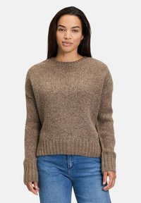 Ruske knitted sweater med rund halsudskæring, ribbede manchetter og kant, samt en struktureret finish. Sammen med blå jeans for kontrast.