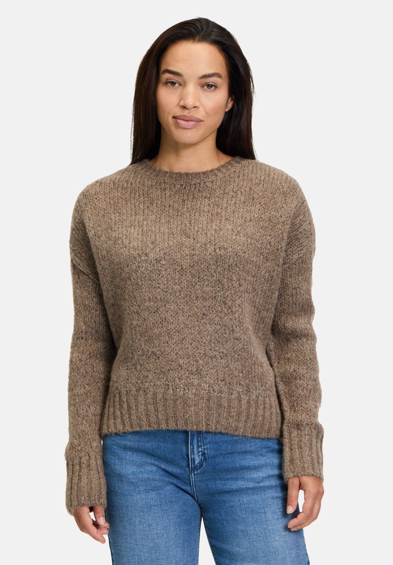 Ruske knitted sweater med rund halsudskæring, ribbede manchetter og kant, samt en struktureret finish. Sammen med blå jeans for kontrast.