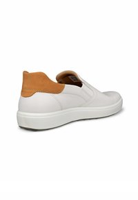 Sneaker bianco slip-on con accentuazione in suede beige sul tallone, tomaia in pelle liscia, suola in gomma e pannelli laterali elastici per una facile calzata.