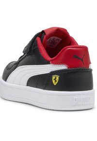 Juodos odinės sportinės bateliai su baltais dryžiais, raudonais akcentais ir "Ferrari" logotipu. Turi paminkštintą apykaklę, Velcro juostą ir tekstūruotą baltą padą.