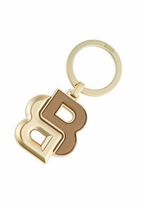 Gold keychain featuring interlocking letters "B" and "D" in contrasting colors, smooth finish, and a circular ring attachment.