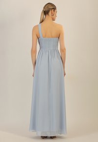 Himmelblaues, einseitiges Maxikleid mit einem gerafften Oberteil und fließendem Rock, hergestellt aus leichtem Stoff. Sanfte Textur und lange Länge.