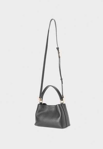Sac à main en cuir noir avec une finition texturée, offrant deux options de port : une courte poignée et une longue sangle réglable. Accents de quincaillerie dorée.