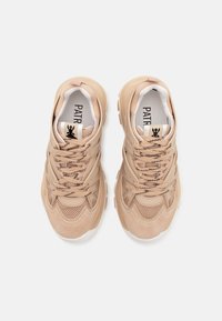 Scarpe sportive beige con materiali in camoscio e rete, punta rotonda, superfici testurizzate e lacci a contrasto. Logo visibile sulla linguetta.