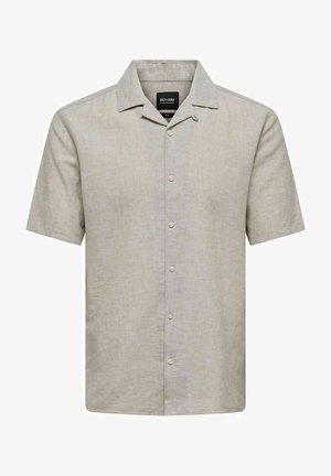 Krēklus ar īsām piedurknēm no gaiši bežām lina šķiedrām. Ieteikta izklājas apkakle, priekšējie pogas un brīva piegriezuma. Gluda tekstūra ar smalku spīdumu.