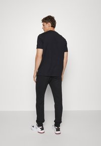 Champion BASIC CUFF PANTS - Tepláky - black