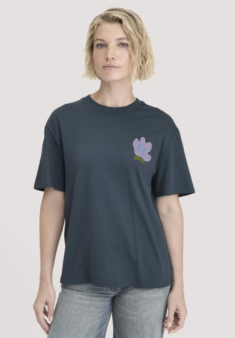 Marineblauwe katoenen t-shirt met korte mouwen. Beschikt over een pastel bloemenafbeelding op de linkerkant van de borst. Klassiek crew neck ontwerp.