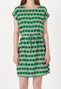 Grünes und beiges kurzes Kleid mit einem geometrischen Muster aus Dreiecken, elastischem Bund und kurzen Ärmeln. Leichter Stoff.
