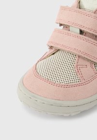 Chaussure en daim rose avec des panneaux en mesh, équipée de deux sangles Velcro. Bout arrondi avec une semelle en caoutchouc texturée et des accents cousus.