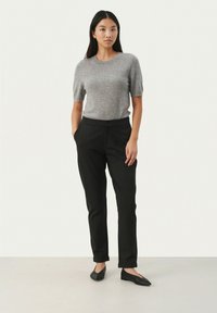 Gray short-sleeve sweater, black tailored pants, and black flats. The outfit features a smooth texture and fitted design with a classic silhouette.
