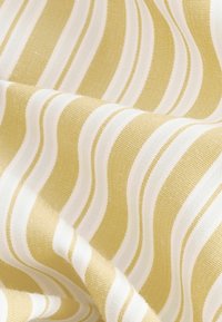 Textil con un patrón ondulado de rayas amarillas y blancas alternas, con una tela texturizada que parece suave y tejida.