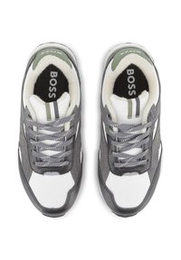 Baskets grises et blanches avec un tissu texturé, des lacets et des accents verts. Présentent un col rembourré et un logo sur la languette.