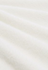 Weißer Fleece-Stoff mit einer sanften, strukturierten Oberfläche. Der Stoff zeigt feine Rillen und hat ein glattes Erscheinungsbild, das das Licht sanft reflektiert.