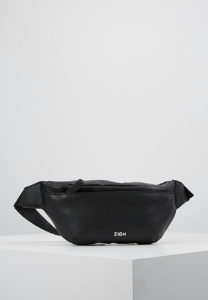 Sort læder bæltetaske med justerbar rem, lynlås lukning og hvidt "ZIGN" logo foran, placeret på en hvid piedestal.