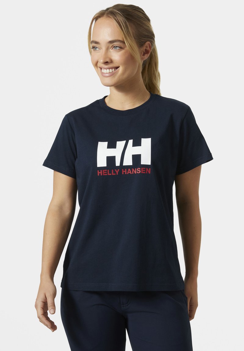 Námořnická modrá bavlněná tričko s bílým logem "HH" a červeným nápisem "HELLY HANSEN" níže. Krátké rukávy a volný střih.