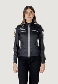 Giacca nera con zip, dotata di strisce bianche sulle maniche, loghi ricamati e due tasche anteriori con zip; materiale liscio e leggero.