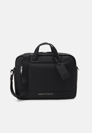 Serviette en cuir noir avec une texture granuleuse, deux poignées de transport, une bandoulière réglable et un logo détaillé à l'avant.