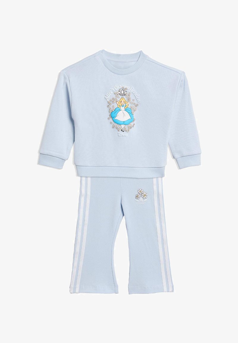 Šviesiai mėlynas džemperis su grafika iš „Alisos stebuklų šalyje“; derančios laisvalaikio kelnės su baltomis juostelėmis ir gegužės žiedų siuvinėjimu ant kišenės.