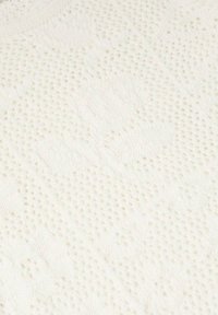 Witte gebreide stof met een textuurpatroon en verheven bloemendessins, met open weving en kabelbreisel details.