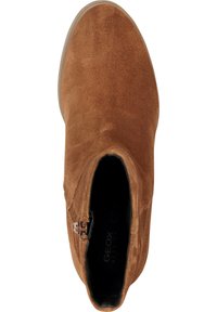 Bottine en daim marron avec fermeture éclair latérale, bout arrondi, surface texturée et semelle extérieure en caoutchouc avec détail de logo subtil.