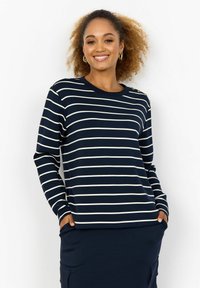 Navy and white striped long-sleeve top with round neckline, side pockets, and decorative buttons on one shoulder. Soft fabric, relaxed fit.