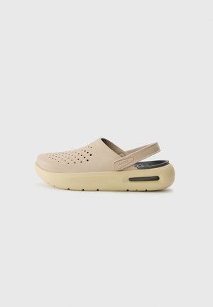 Sabot beige en matériau léger, doté d'un dessus perforé, d'une sangle arrière et d'une semelle jaune contrastante avec une semelle intérieure noire.