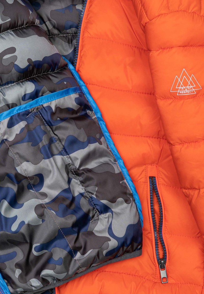 Padded-Jacke mit orangefarbenem Außenmaterial, blauen Akzenten und einem schwarz/grau camo Innenfutter. Enthält eine mit Reißverschluss versehene Tasche und ein Logodesign.