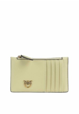 Portafoglio compatto in pelle beige chiaro con scomparto con cerniera, quattro fessure per carte sulla destra e un piccolo emblema decorativo dorato sul davanti.