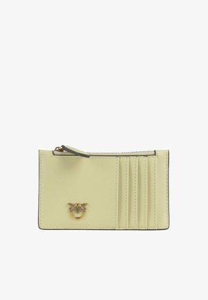 Portafoglio compatto in pelle beige chiaro con scomparto con cerniera, quattro fessure per carte sulla destra e un piccolo emblema decorativo dorato sul davanti.