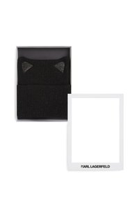 Chapeau en tricot noir à côtes avec des accents métalliques et un design d'oreilles de chat, présenté dans une boîte grise avec une carte blanche portant le logo "KARL LAGERFELD".