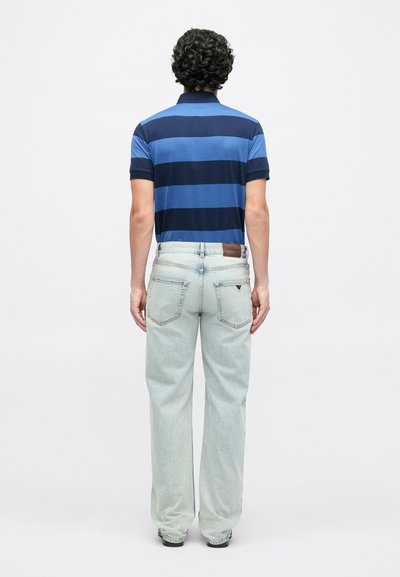 Μπλουζάκι πόλο με μπλε και ναυτικό ρίγες και κοντά μανίκια· τζιν ελαφριάς πλύσης με χαλαρή εφαρμογή και πίσω τσέπες· απλό σχέδιο με δερμάτινη ετικέτα.