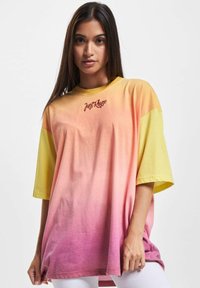 Oversized t-skjorte i en gradient fra gul til rosa, laget av myk bomull. Har "JustRhye"-logo i mørkerød på brystet. Korte ermer.