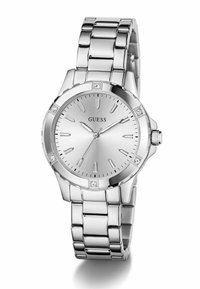 Montre en acier inoxydable argenté avec un cadran rond, accentuée de diamants aux positions 12, 3, 6 et 9 heures, et un bracelet articulé poli.