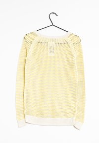 Pull en maille jaune avec un tissage large et lâche, col et ourlet côtelés, suspendu à un crochet noir. Il présente des manches longues et une coupe décontractée.