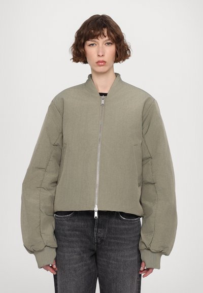 Olivově zelená zkrácená bomber bunda se zipem vpředu, žebrovanými manžetami a oversize rukávy. Vyrobena z texturovaného, lehkého materiálu.