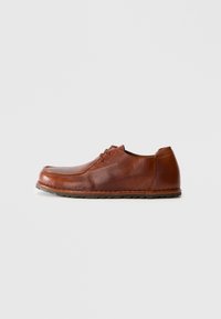 Brown leather lace-up men's shoe with textured surface and rubber sole, shown from the side on a plain white background.
