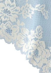 Vaaleansininen pitsikangas, jossa on monimutkainen valkoinen kukkakirjonta ja aaltoilevat reunat, esittelee teksturoitua kuviointia.