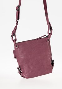 Borsa a tracolla viola in pelle con tracolla regolabile, chiusura con zip e due elementi decorativi in metallo nero sui lati. Superficie testurizzata.
