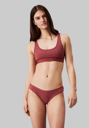 Costume da bagno color ruggine con tessuto testurizzato. Il top ha un scollo ad anello e spalline larghe, mentre la parte inferiore presenta un taglio classico.