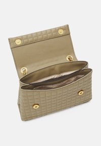Borsa a busta trapuntata beige con hardware dorato, dotata di due scomparti e una foderatura interna liscia. Chiusure a scatto doppie sulla parte superiore.