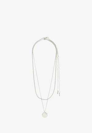 Hõbe mitme kihiga kaelakee, millel on struktureeritud ümmargune ripats, erineva pikkusega kettid ja väikesed aksessuaarcharmid.