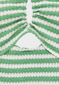 Pletený oděv s jednou a bílou pruhovanou alternací, texturovaná látka s nařaseným detailem ve středu a výřezem na dně.